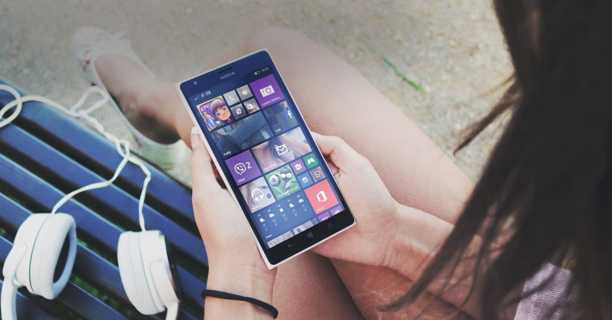 User holding a sleek Windows Phone, showcasing its design.